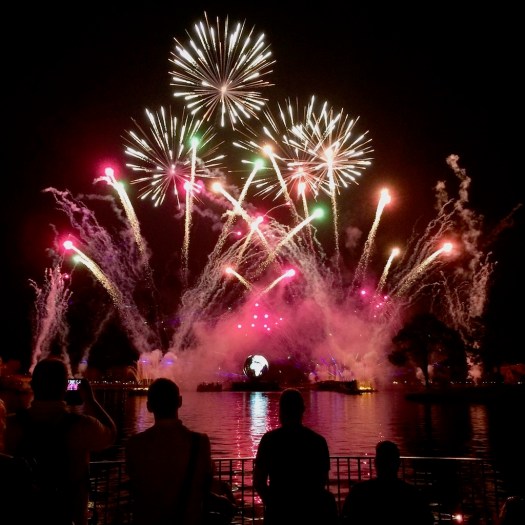 People watching an evening firework display at Epcot