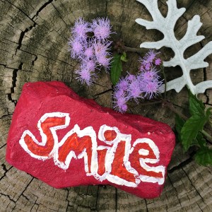 Red painted stone with smile painted on it