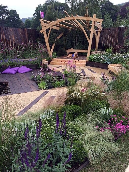Garden with wooden arbour and purple flowers