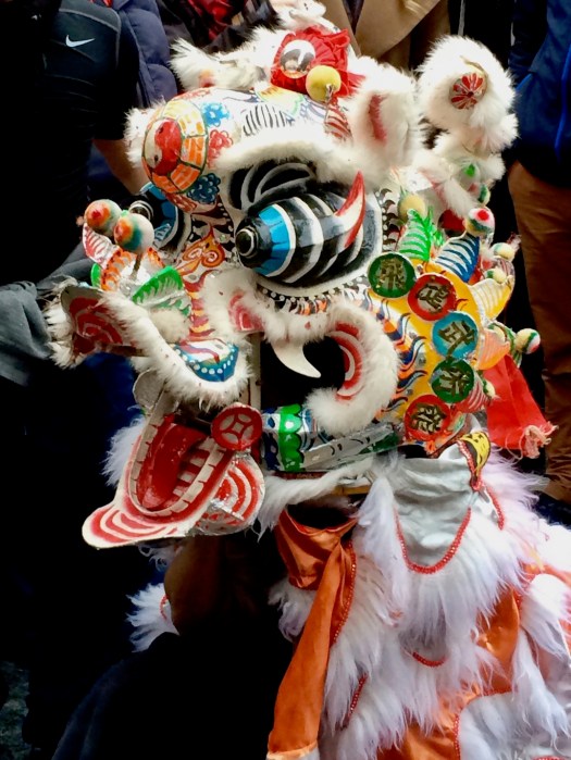 Colourful lion mask with protruding eyes and wide open mouth
