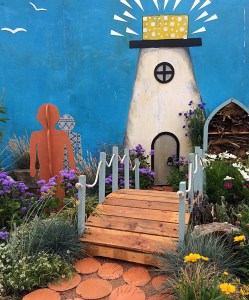 Arched wooden bridge in a garden with abstract human figures