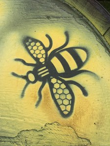 Black bee motif picked out with yellow spray paint