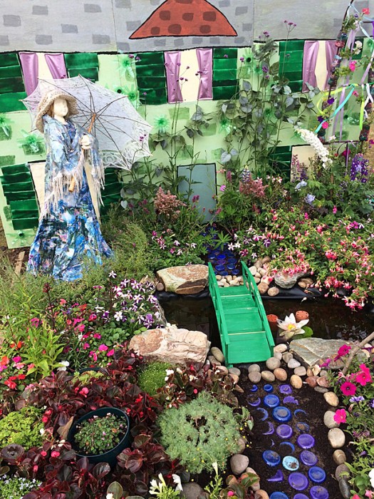 House backdrop, with lady holding a parasol in a garden