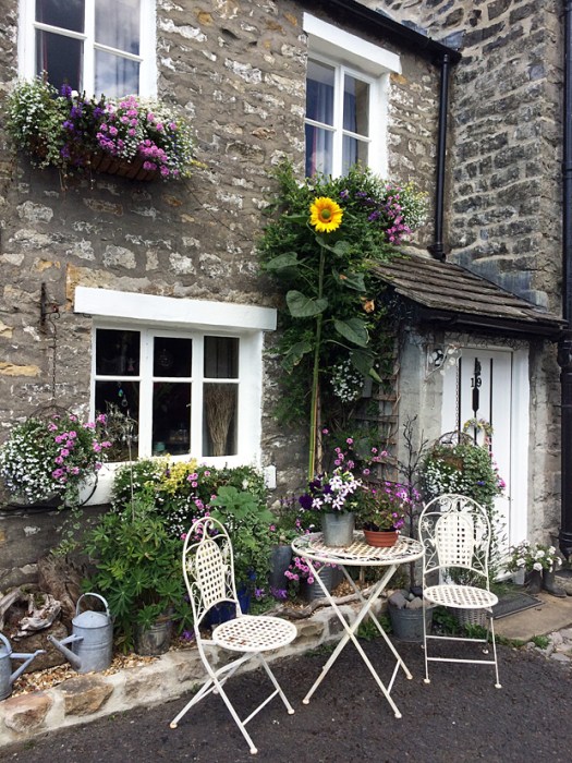 A seating area outside a terraced house with flowers