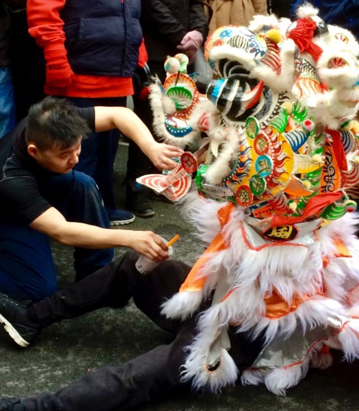 Lion dancer being offered a drink
