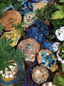 Tree trunk segments decorated in blues and yellows