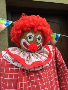 Smiling clown with red curls and red checked costume