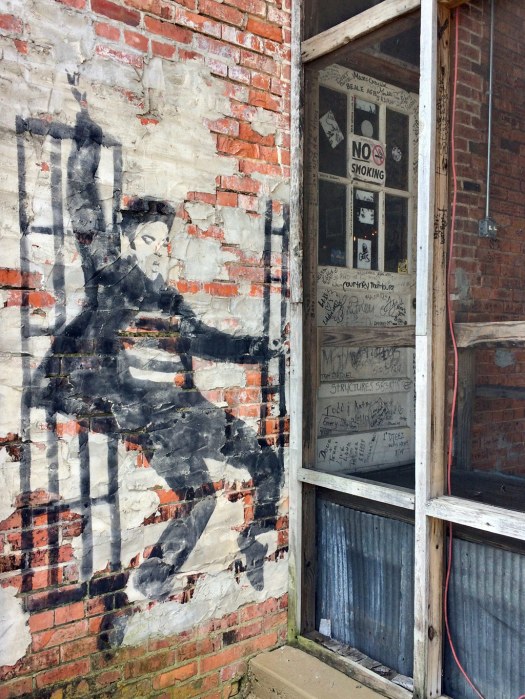 Elvis, dancing alone, with one hand held high