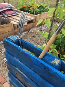 Pallet painted blue turned sideways makes a tool store