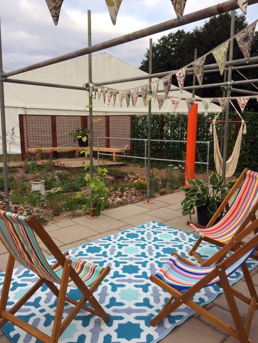 Community garden on a brownfield site with deckchairs and bunting
