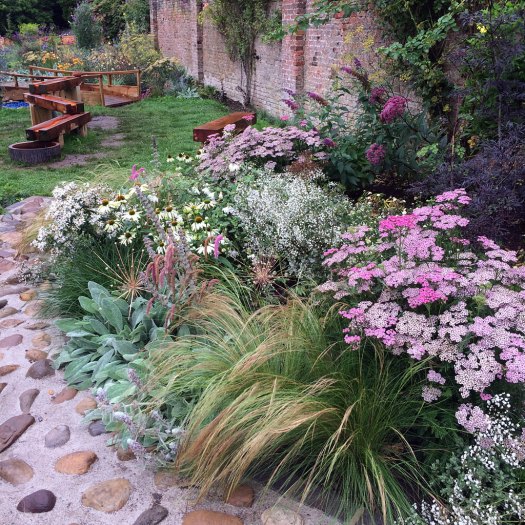 Flower garden with a tall brick wall at the rear