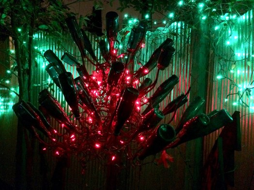 Bottle tree at night with red and green lights