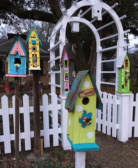 Entryway to home, decorated with five tall birdhouses