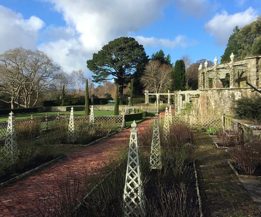 Obelisks and pergolas in a garden of pruned back roses