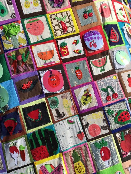 Patchwork throw with smiling fruits drawn by kids