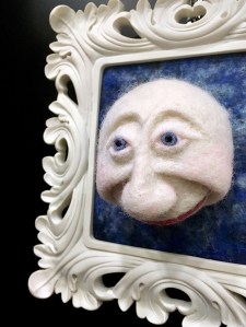 Three dimensional moon face in a white frame