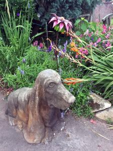 Stone Basset Hound beside a garden