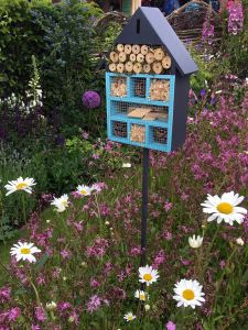 Blue insect hotel on a pole