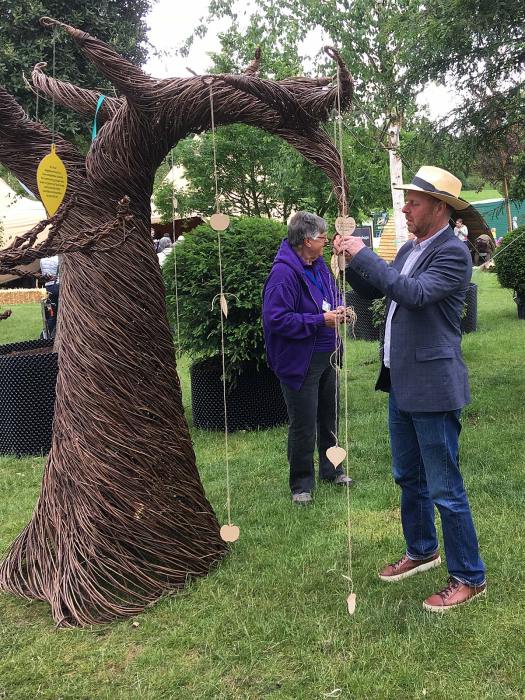 Joe Swift ties a wish to a wicker tree
