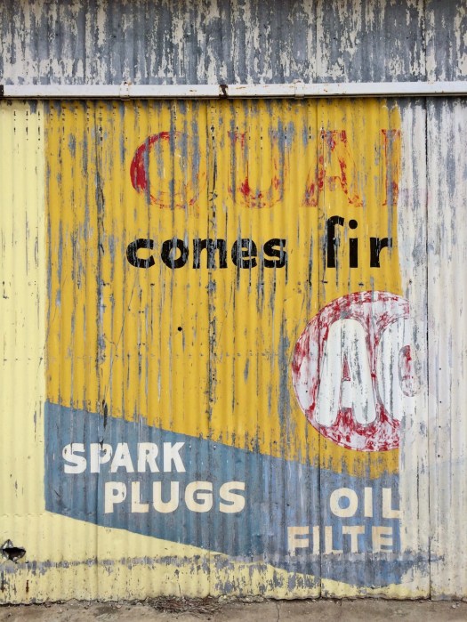Faded advert on a garage wall