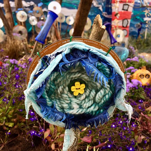 CD bird scarer with wool, rags and feathered trim