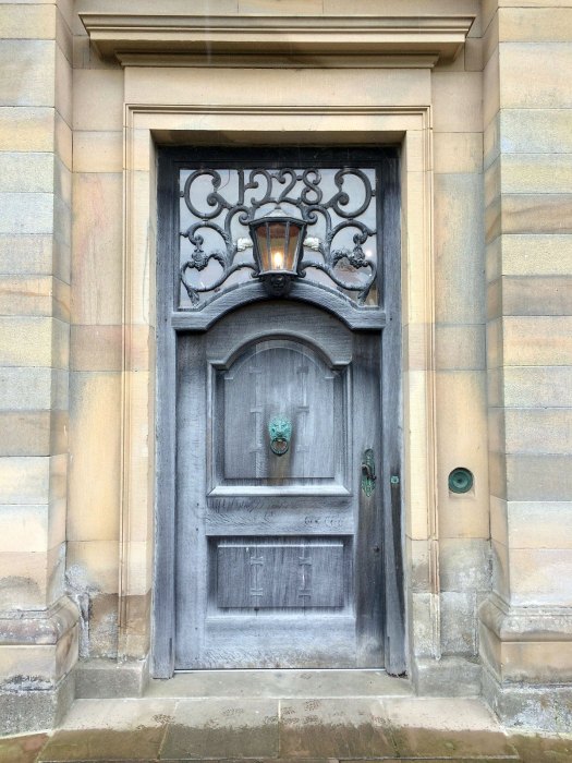 Traditional door with light and ornate knocker at Howick Hall
