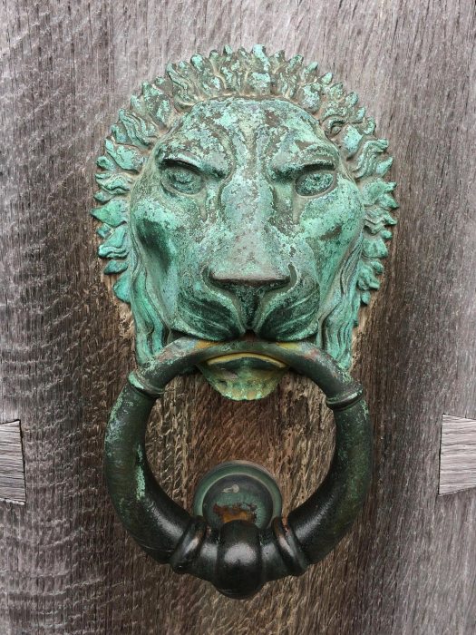 Door knocker held in the mouth of a lion