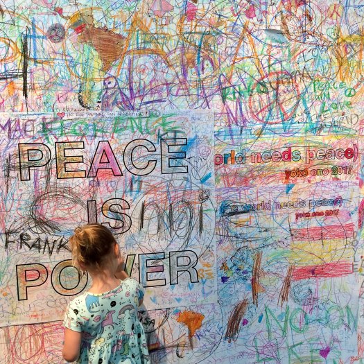 Child drawing on a peace wall at the Double Fantasy exhibition