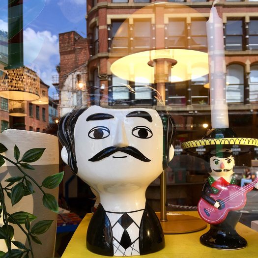 Shop window with reflected buildings in Manchester's Northern Quarter