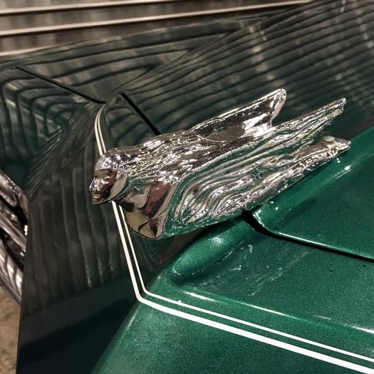 Flying lady hood ornament on green vintage car