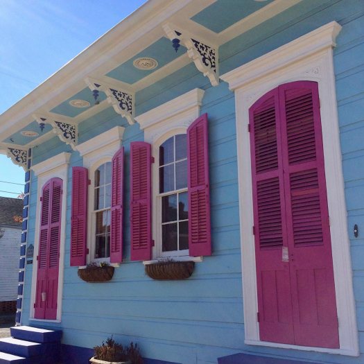 Pale blue house with purple door and shutters