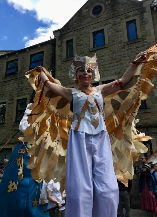 Stilt walker with golden wings