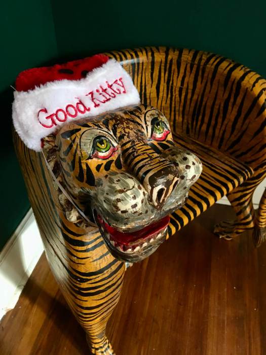 Wooden seat shaped and painted like a tiger with a Good Kitty hat