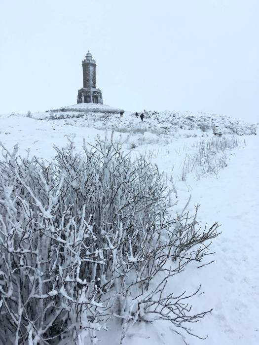 People walking to Darwen Jubilee Tower in the snow