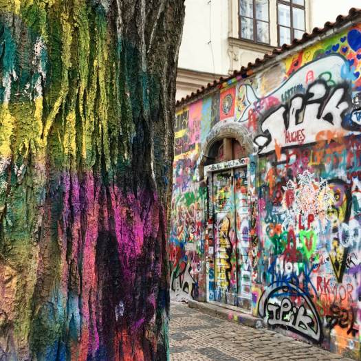 Painted tree trunk with the John Lennon wall, Prague