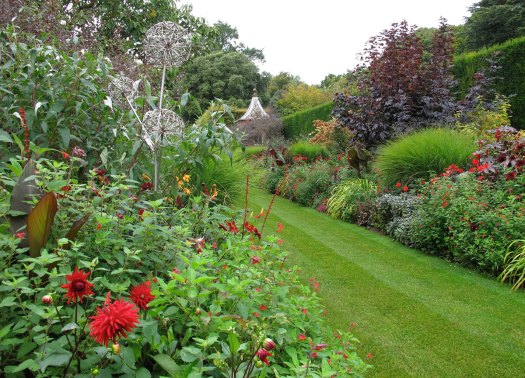 Red dahlia and allium sculpture at Hidcote Garden