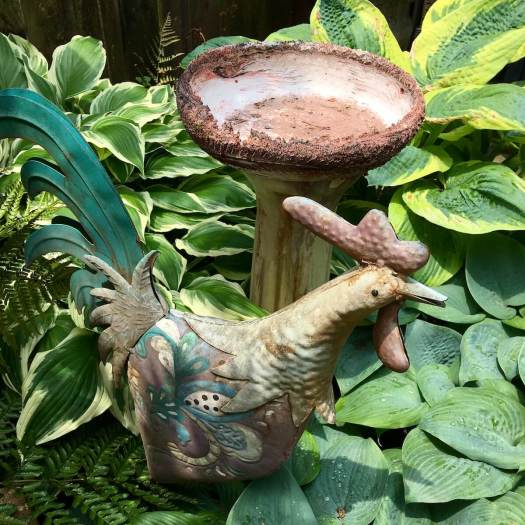 Cockerel yard art, hostas and bird bath