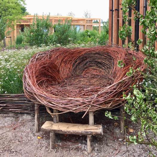 Large garden seat made from woven sticks and natural wood