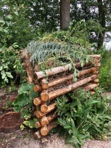 Triangular compost heap made from logs