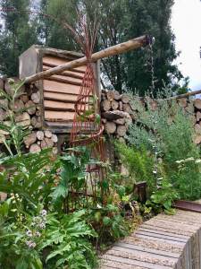 Raised plant bed with a wicker obelisk