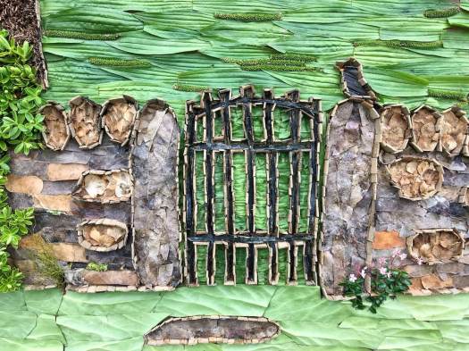 Well dressing detail with dry stone wall, gate and bird