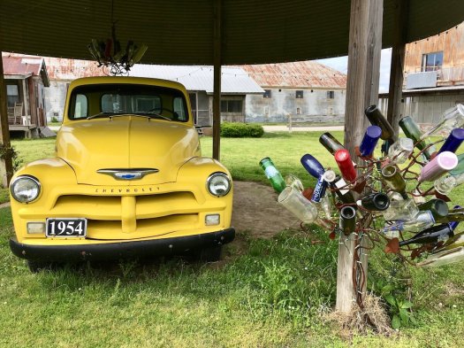 Yellow 1954 Chevrolet with Stephanie Dwyer bottle tree and chandelier, Shack Up Inn