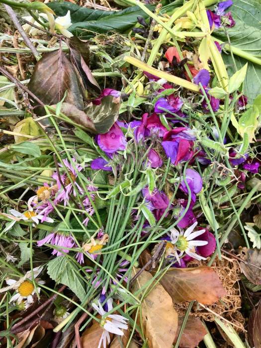 Leaf pile topped with daisies and sweet peas