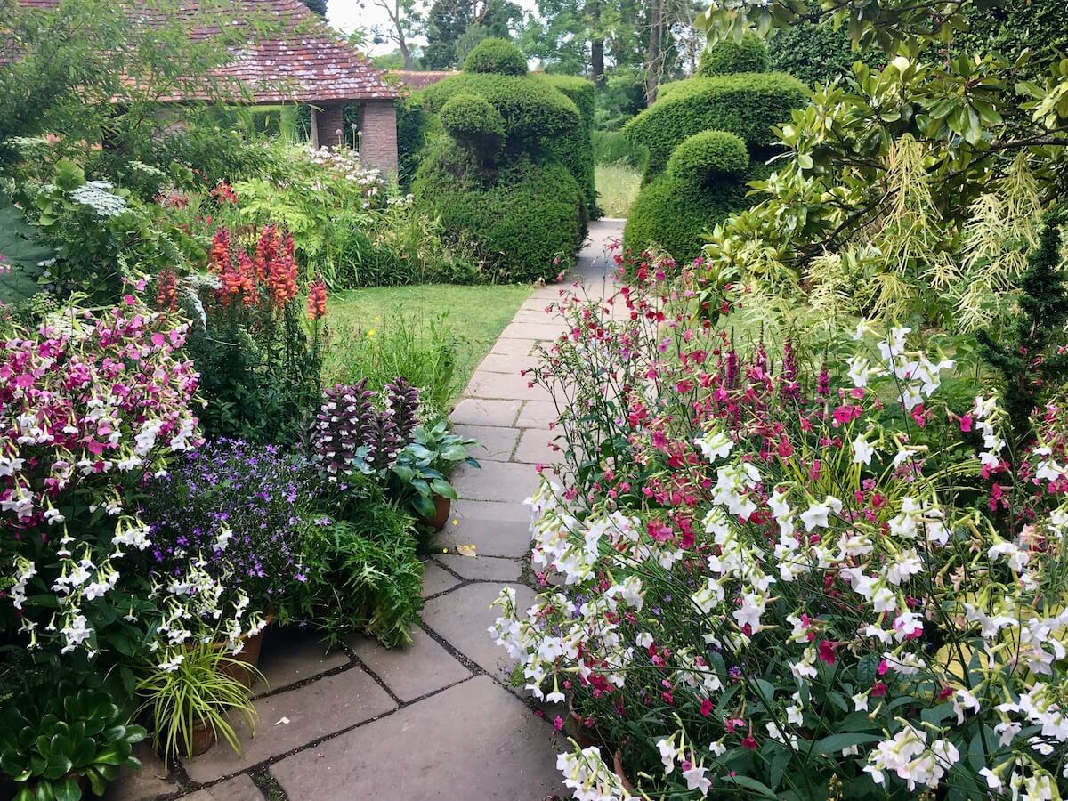 Path leading through flowers to topiary birds
