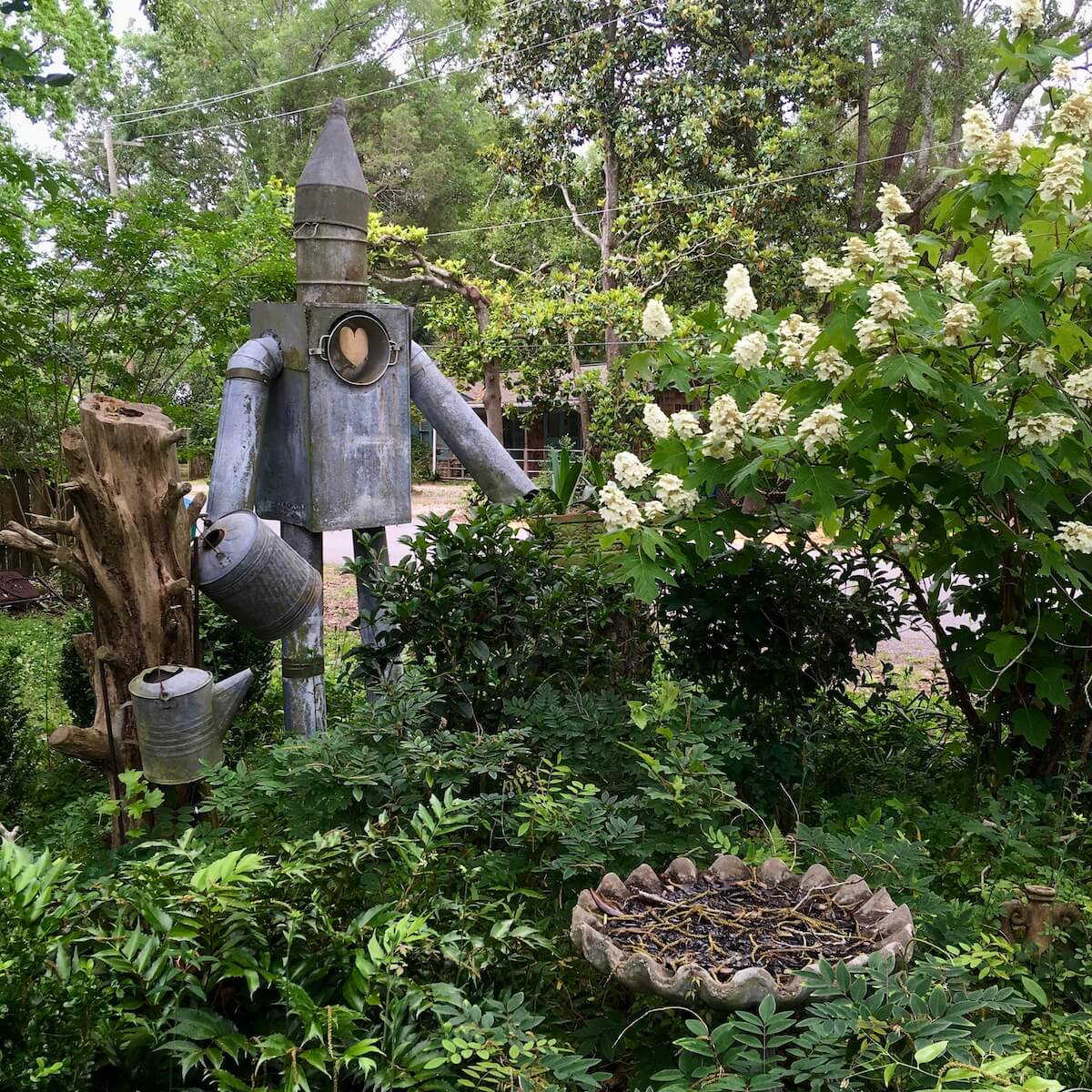 Tin man with watering cans (and heart) in a garden