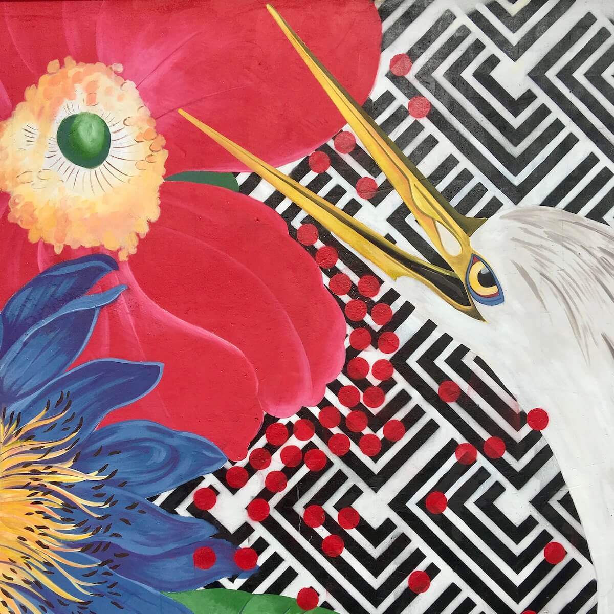 Head of a bird with its beak open with flowers and a geometric pattern