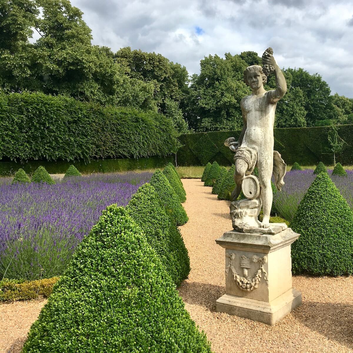 Statue of Bacchus in a parterre garden with lavender and trimmed box at Ham House