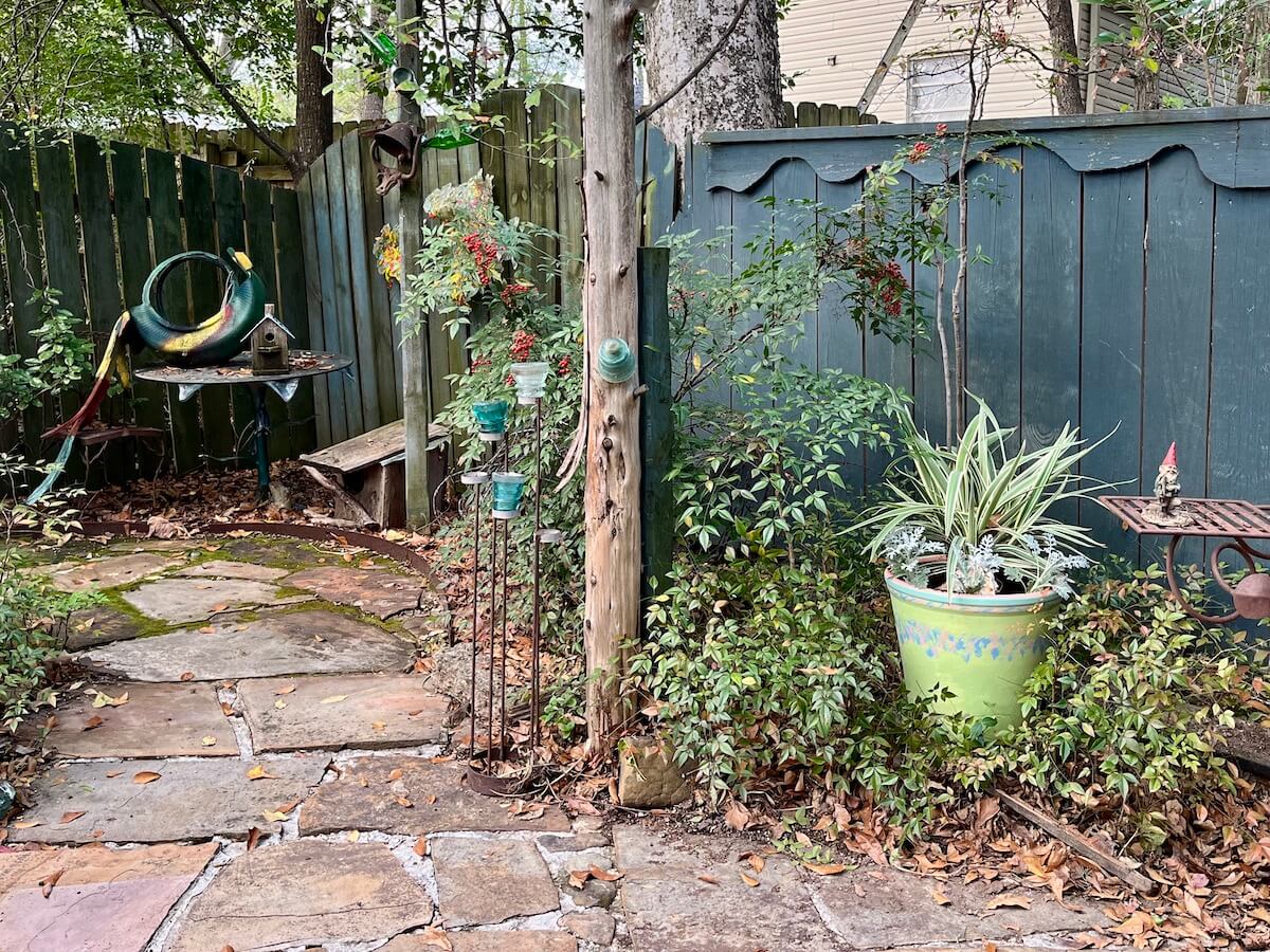 Hand-painted green pot with contrasting bands of colour in a garden